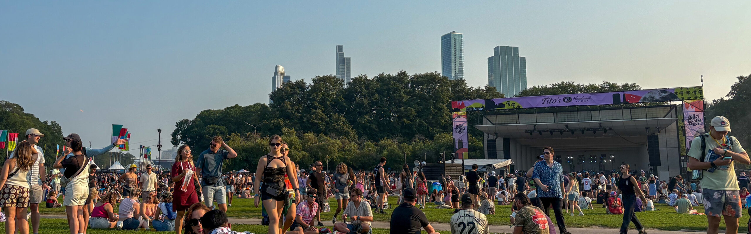 Attendees relaxing on the grass during Sueños Music Festival in Chicago’s Grant Park with a live stage in the background