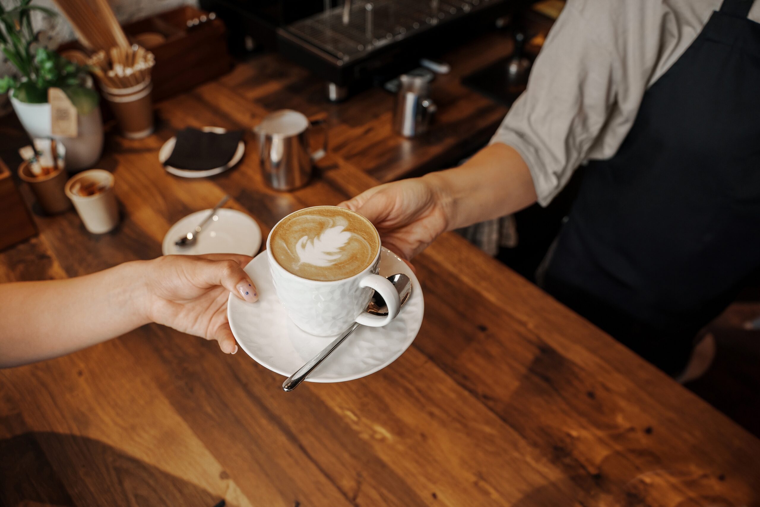 Latte with leaf art served at one of the best coffee shops in Chicago, featuring a warm wooden café interior.