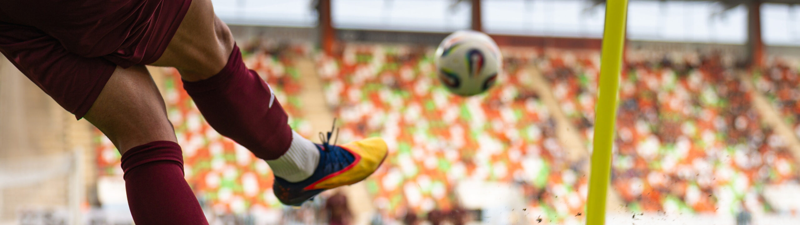 Close-up of a soccer player taking a corner kick on a grass field during world championship.