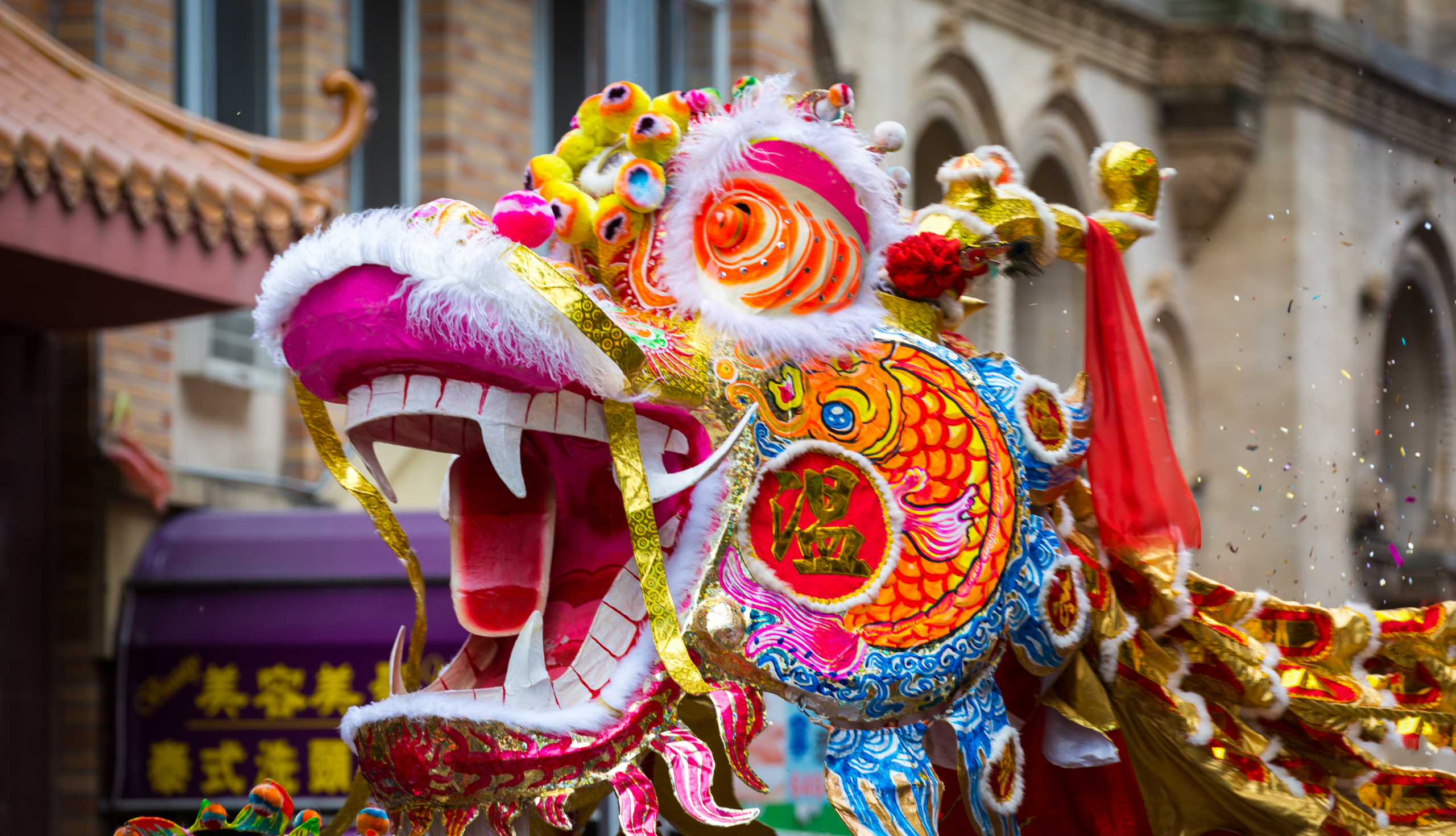 A close-up of a vibrant, ornate dragon dance costume during a Lunar New Year celebration.