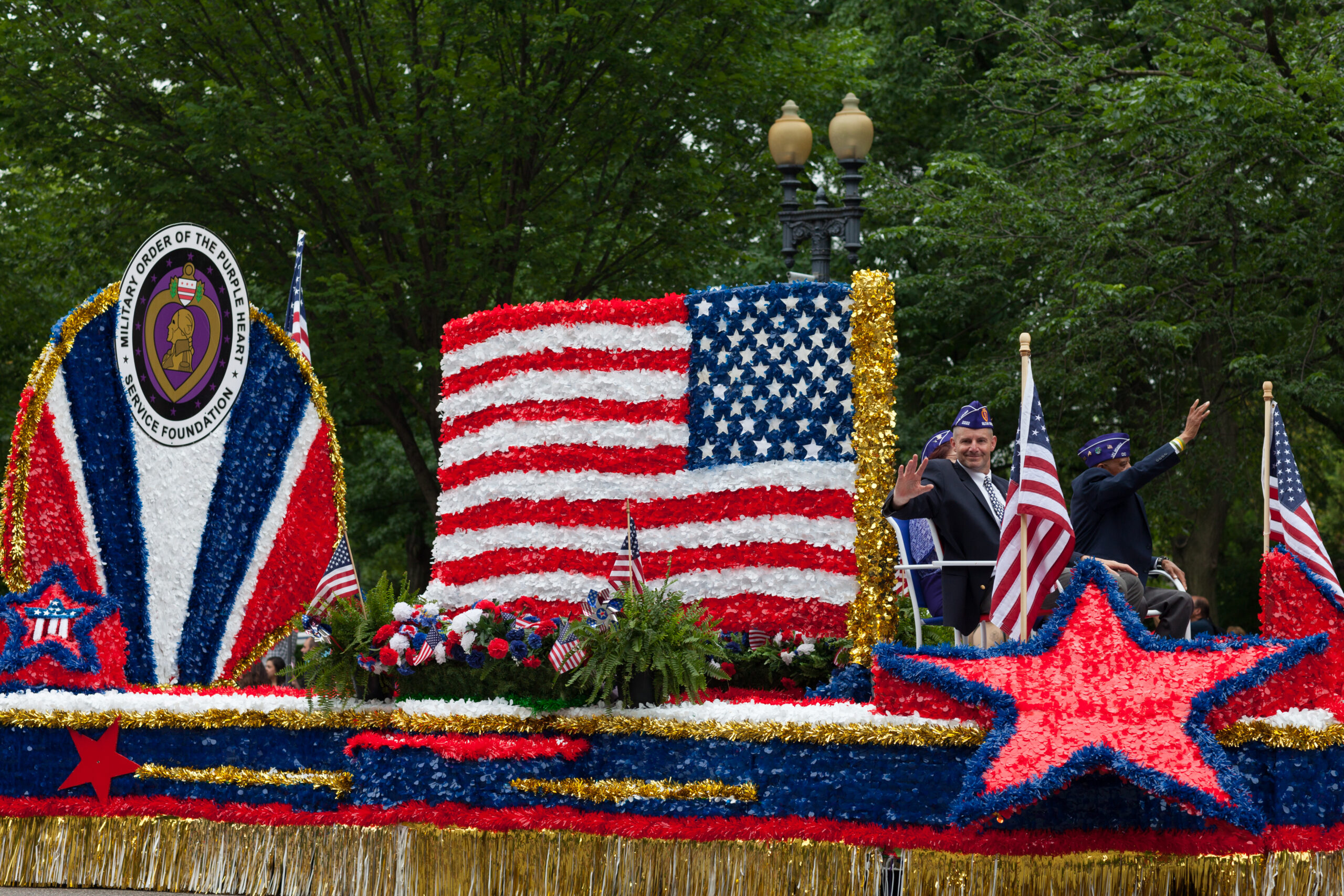 An American flag-themed parade float for the Military Order of the Purple Heart Service Foundation participates in a Memorial Day parade.