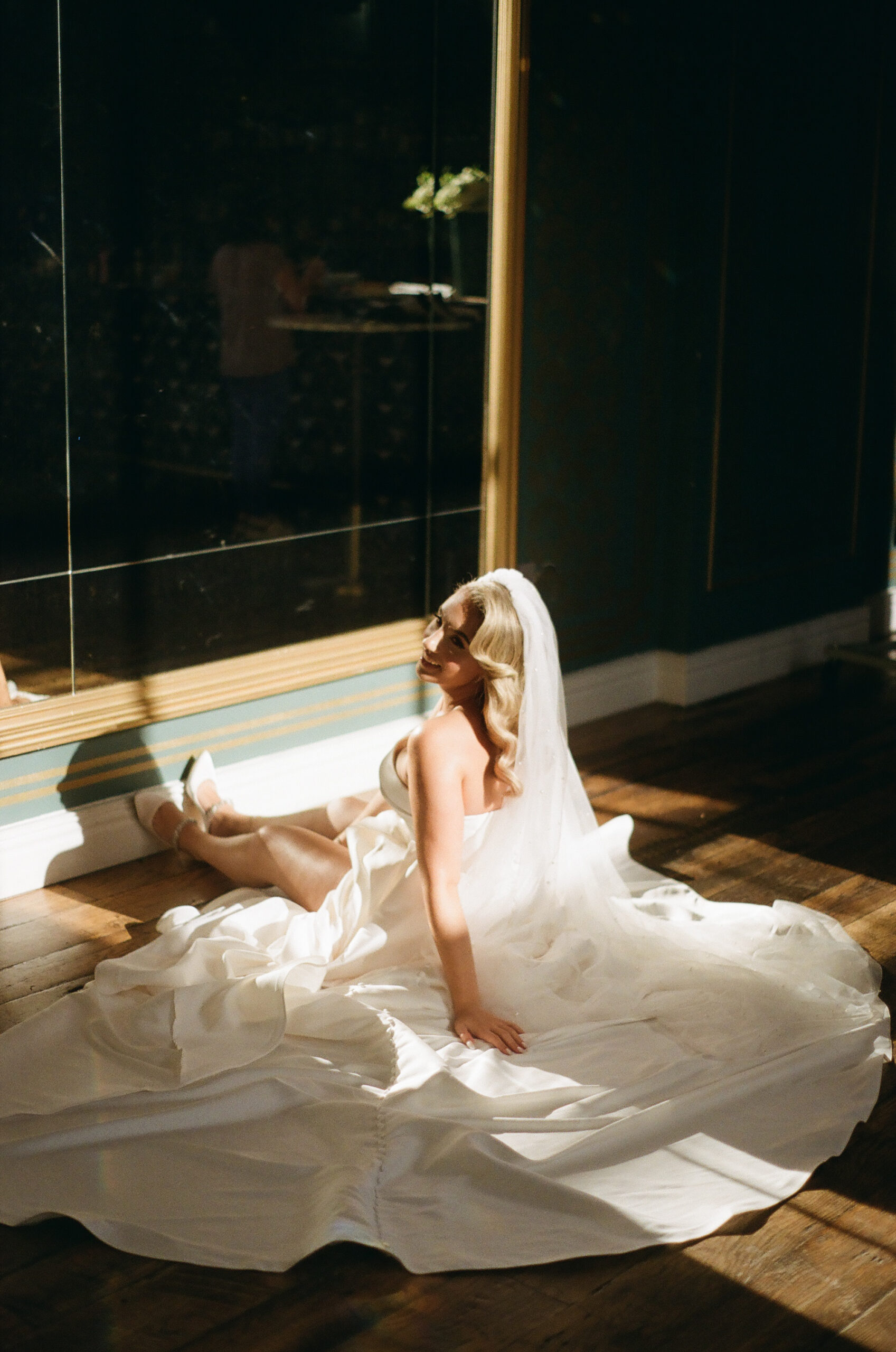 Woman in a wedding dress sitting on the floor of the Arlo Williamsburg ballroom