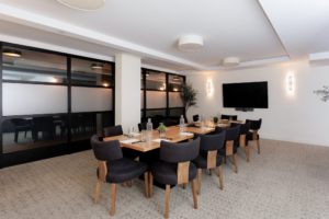 Meeting room at Arlo Williamsburg with conference table, chairs, and screen for presentations