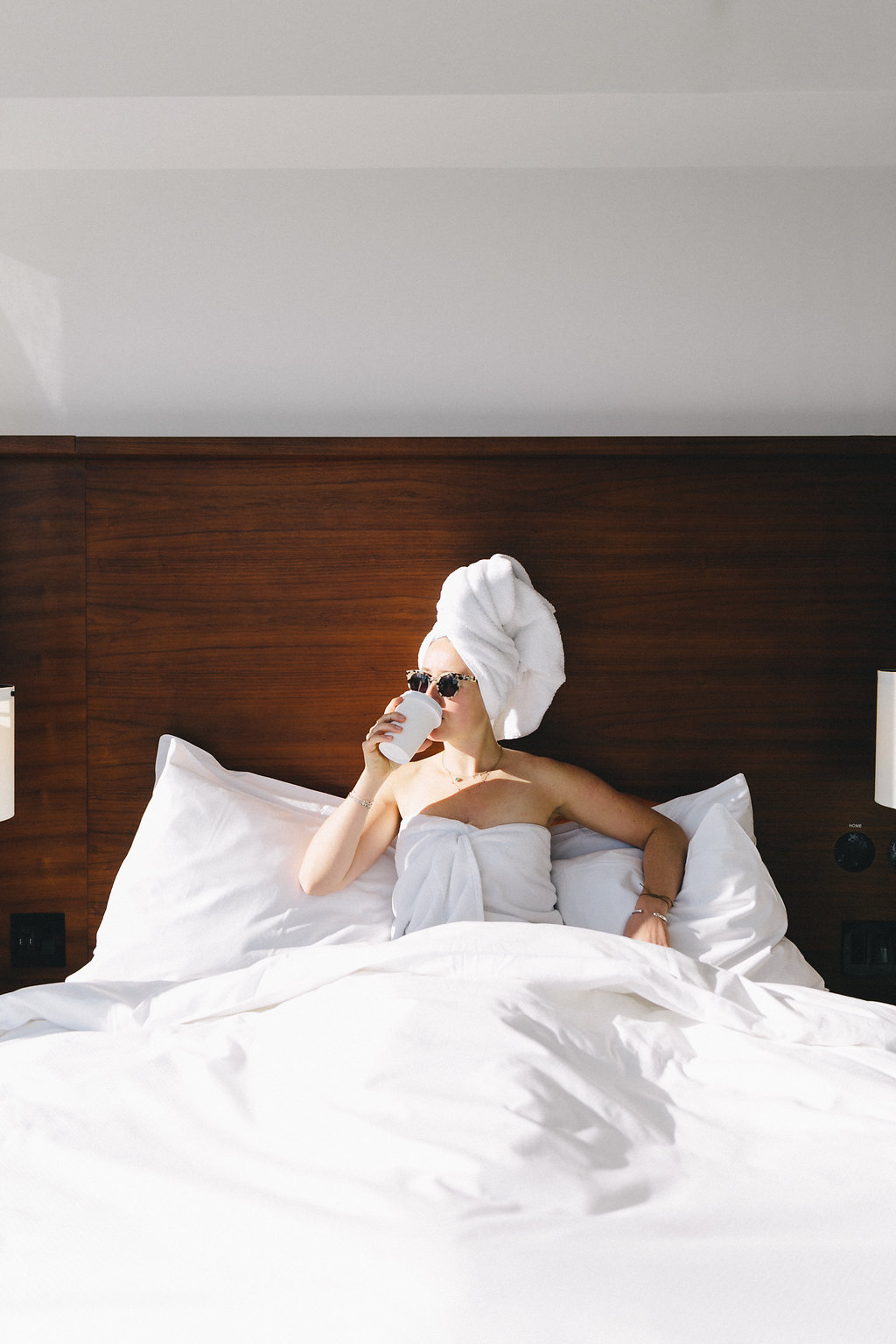 woman in bed in bathrobe sipping coffee