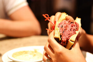 Arlo Hotels Blog Woman holding a pastrami sandwich in New York