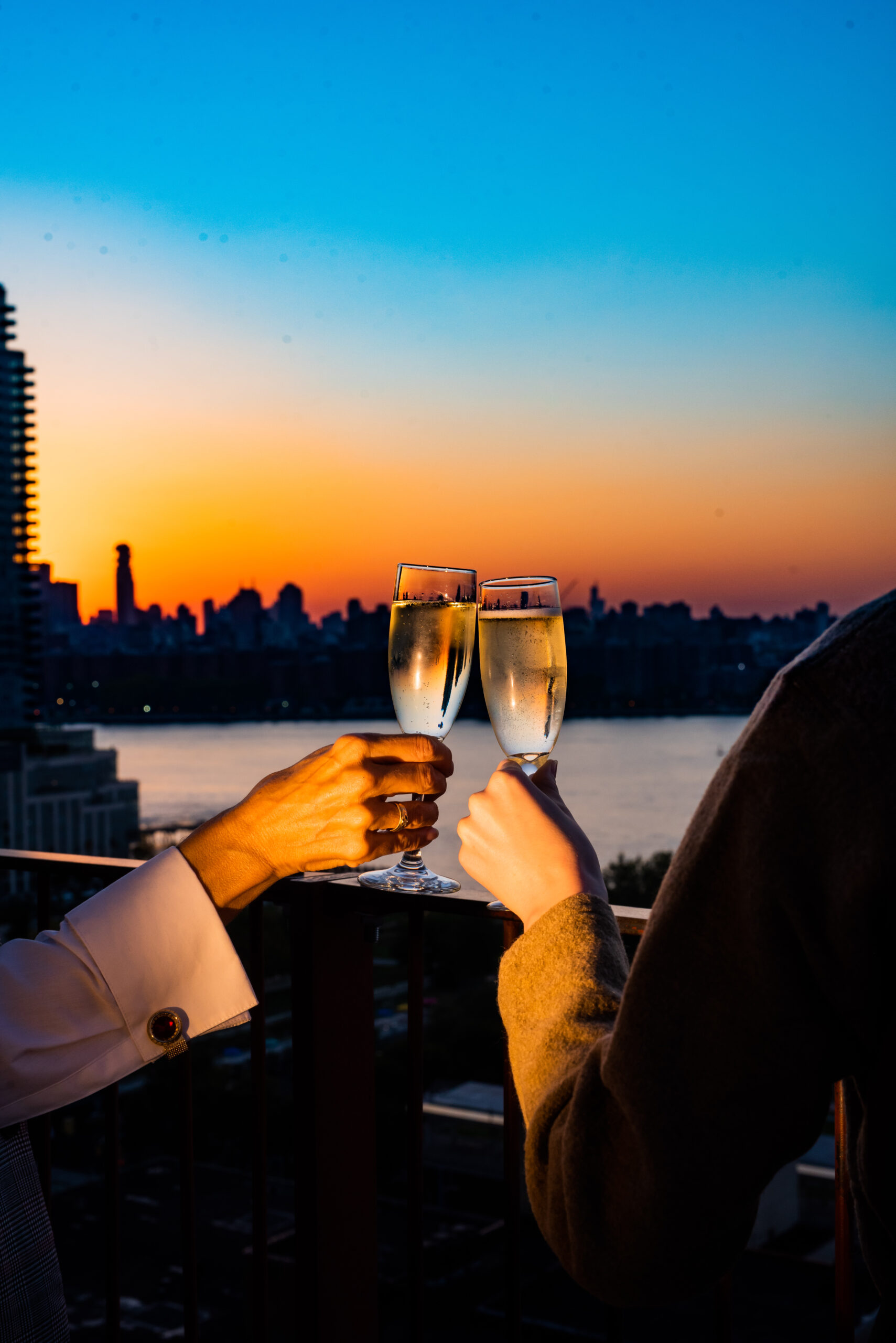 Clinging glasses of champagne at sunset
