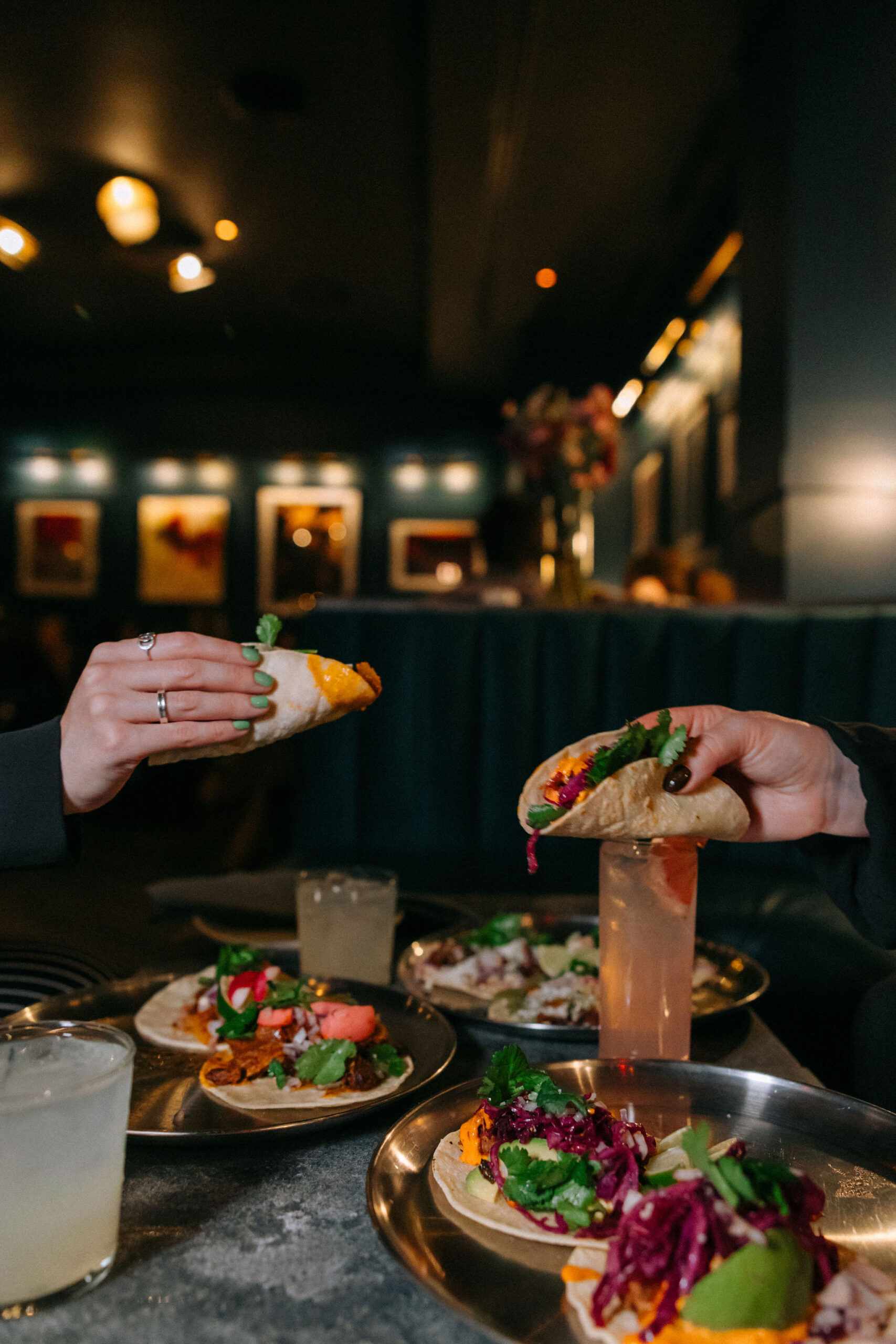 Two hands holding tacos at ART SoHo