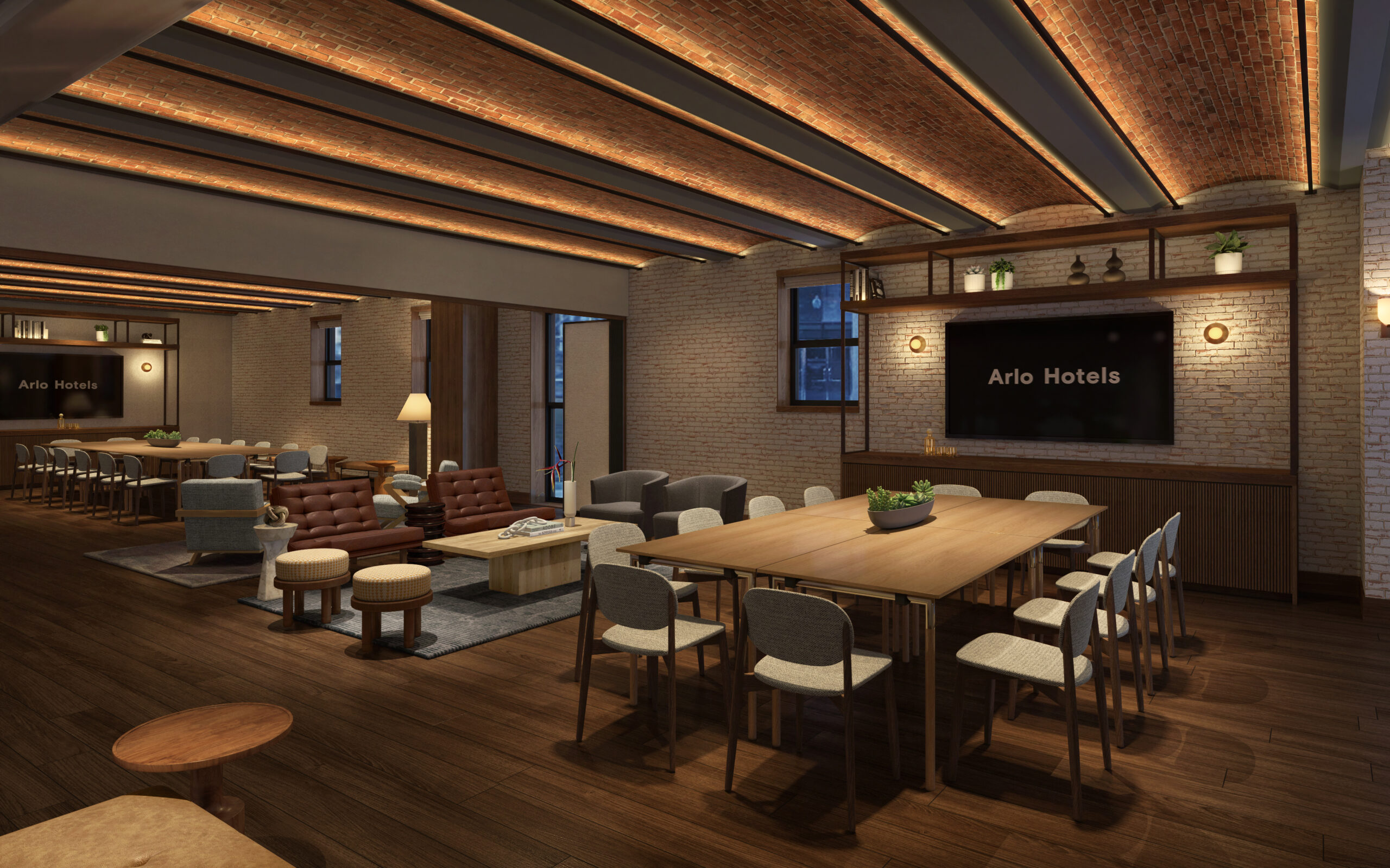 A modern hotel lounge with wooden floors, a long communal table, leather seating, and shelves. The walls are brick, and the ceiling has wooden beams. A sign reads "Arlo Hotels.