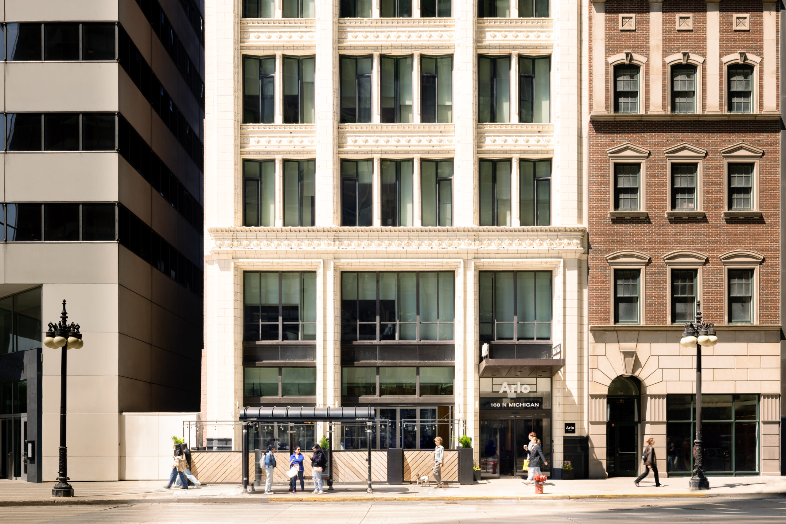 Street view of a row of commercial buildings with people walking on the sidewalk in front of the Arlo property at 168 N Michigan Avenue.