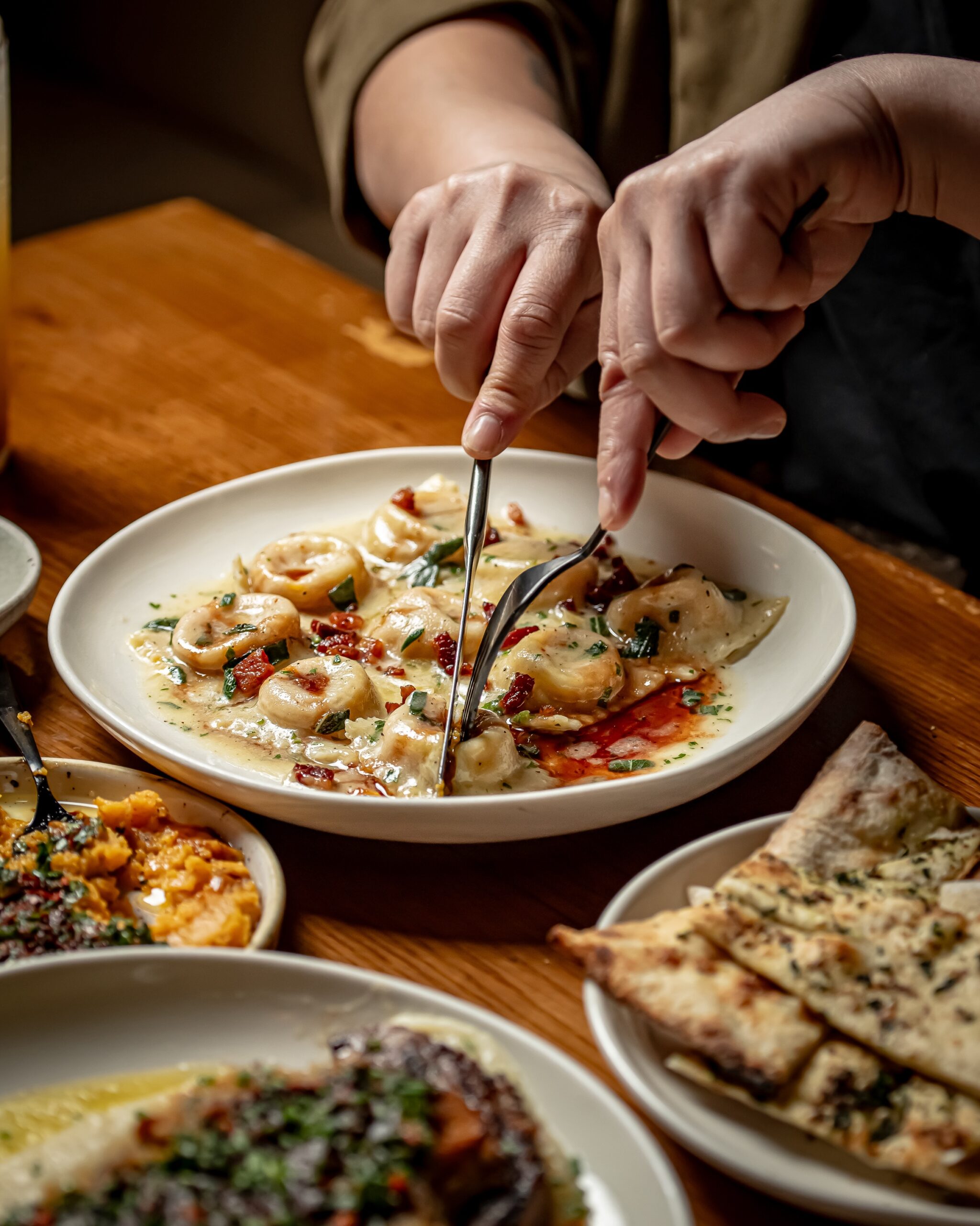 A person eating food with a fork and knife.