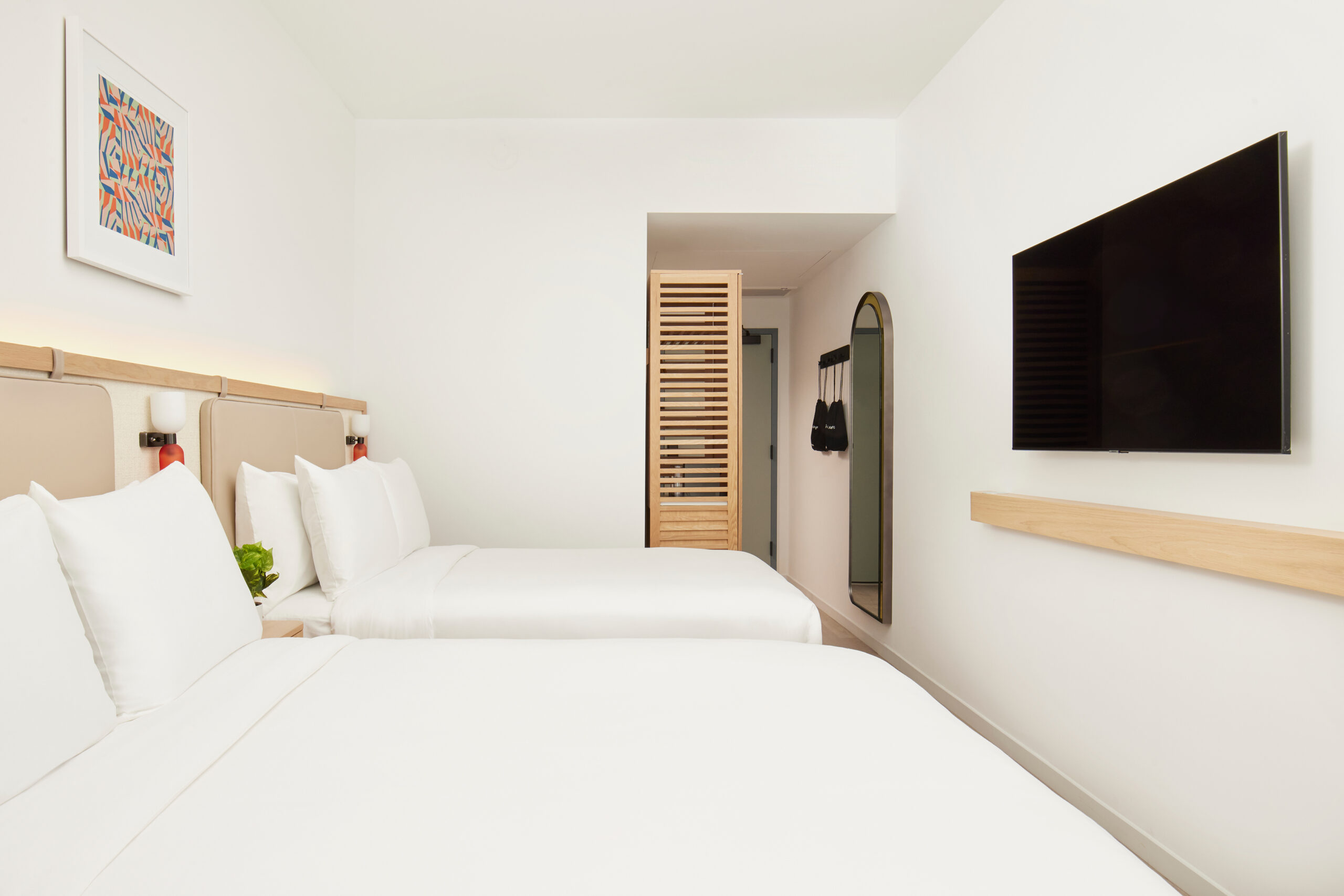 Arlo Wynwood Two Double hotel room beds, television, and entryway